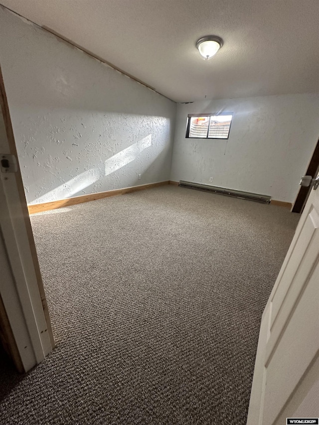 interior space featuring a textured ceiling, baseboard heating, and carpet