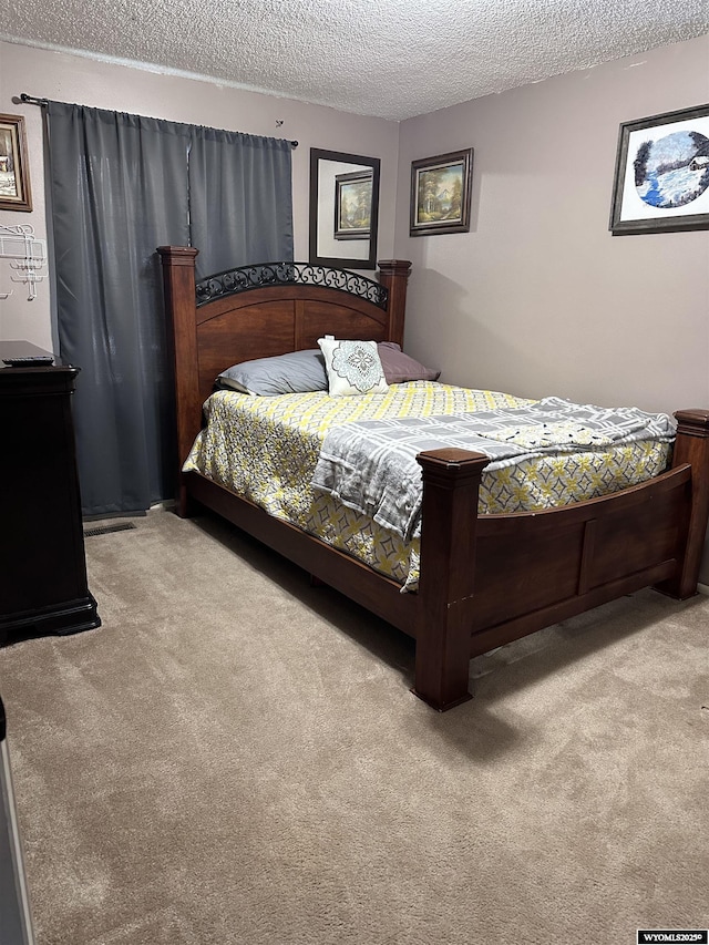 bedroom featuring a textured ceiling and carpet flooring