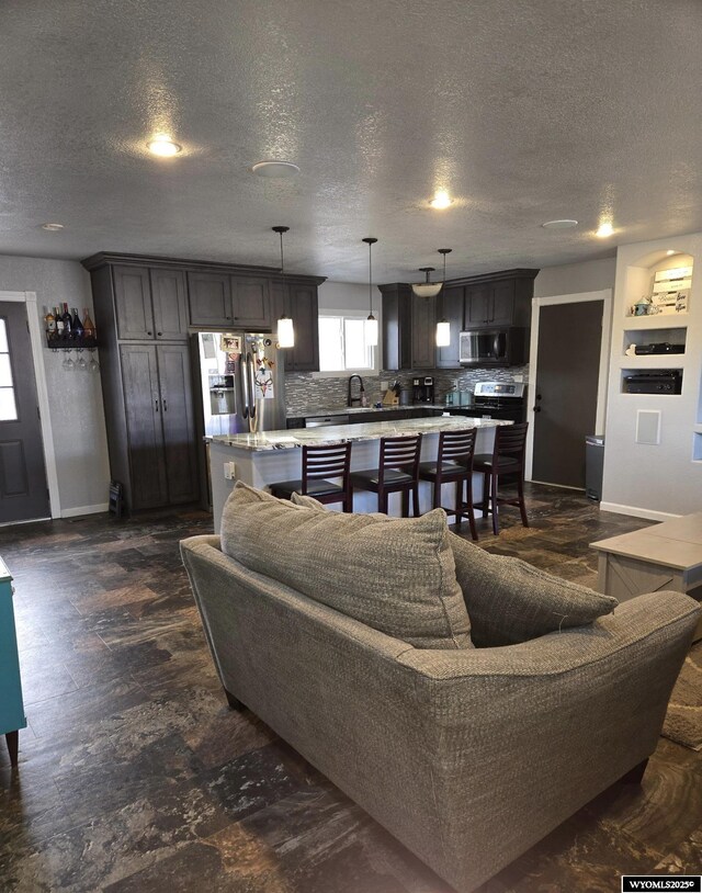 living area featuring a textured ceiling and baseboards