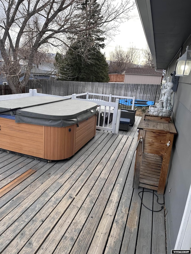 deck with a fenced backyard and a hot tub