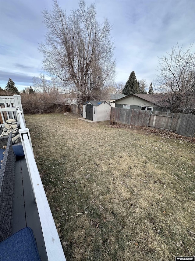 view of yard featuring an outbuilding, fence, and a storage shed