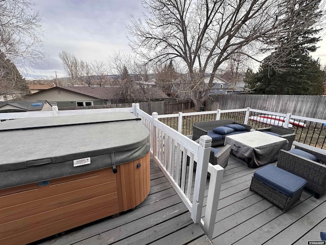 wooden deck featuring a hot tub, an outdoor hangout area, and a fenced backyard