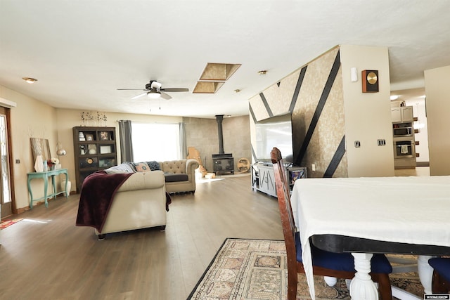 interior space with hardwood / wood-style floors, ceiling fan, and a wood stove