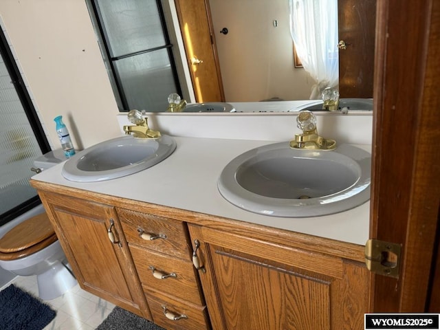 bathroom with toilet, tile patterned floors, and vanity