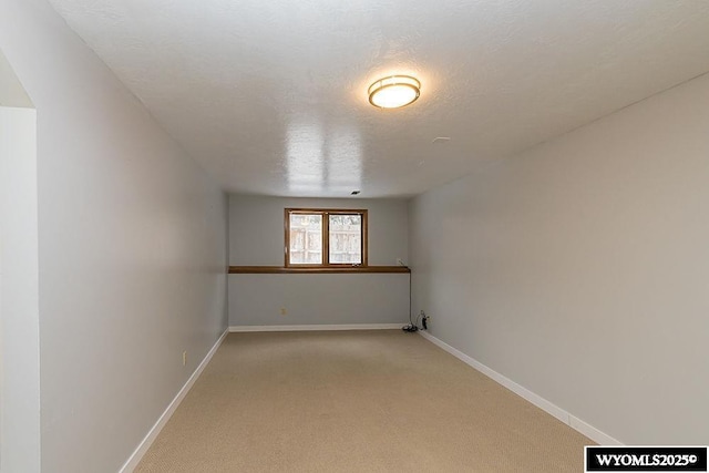 additional living space with a textured ceiling and light carpet