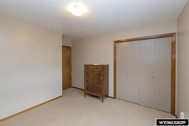 unfurnished bedroom featuring light carpet and a closet