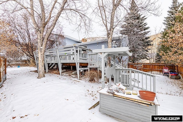 snow covered rear of property featuring a deck