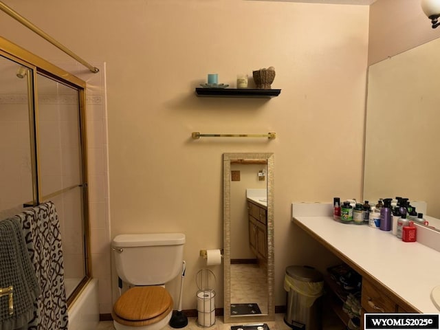 full bathroom with toilet, vanity, and shower / bath combination with glass door