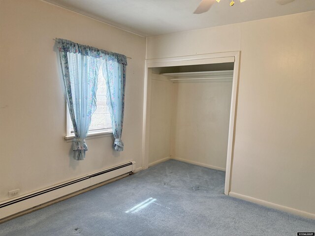 1101 Pine Ave, Kemmerer, WY 83101 - unfurnished bedroom with baseboard heating, a closet, a ceiling fan, and carpet