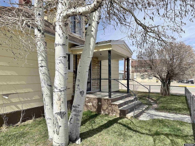 1101 Pine Ave, Kemmerer, WY 83101 - view of side of home featuring fence, covered porch, and a yard