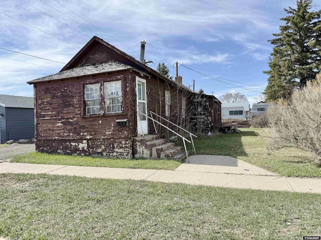 1101 Pine Ave, Kemmerer, WY 83101 - bungalow-style home featuring a chimney, entry steps, and a front yard