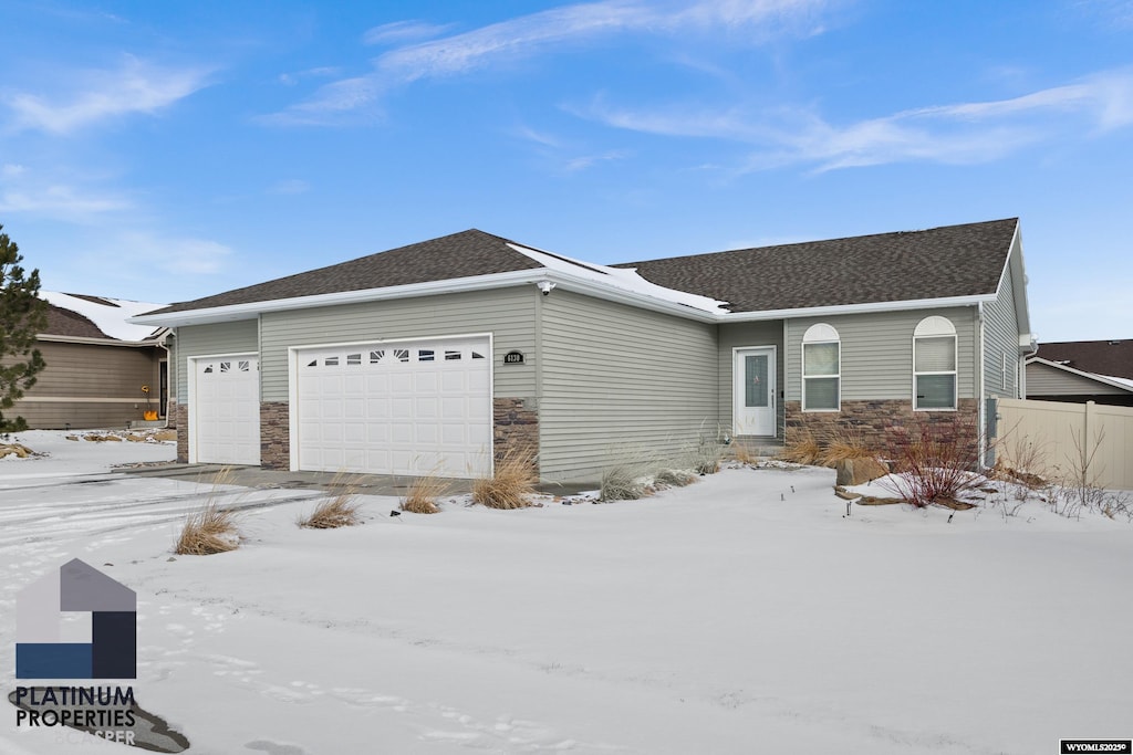 ranch-style home featuring a garage and stone siding