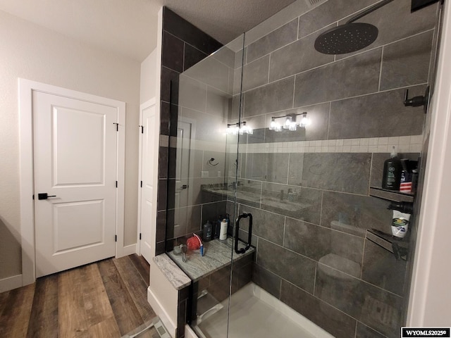 bathroom featuring a shower with shower door and wood-type flooring