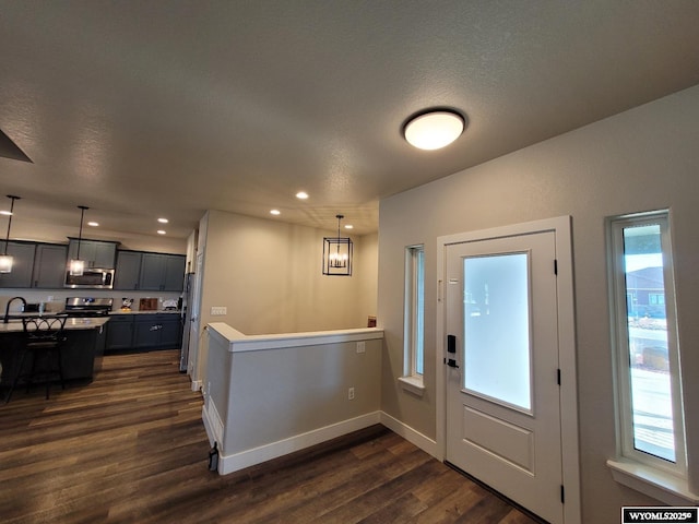 entryway featuring dark hardwood / wood-style flooring, a textured ceiling, and a wealth of natural light