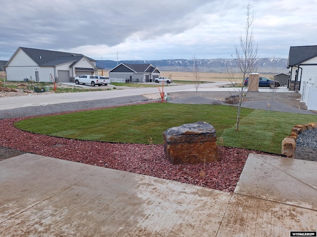 view of yard with a garage and a mountain view