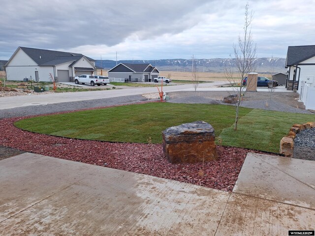 view of yard with a mountain view and a garage