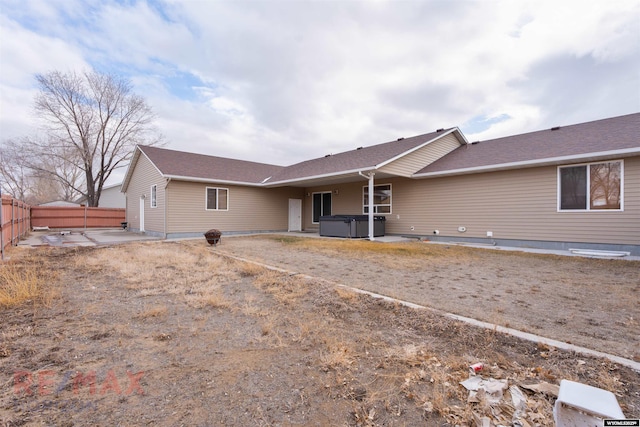 back of property featuring a hot tub and a patio