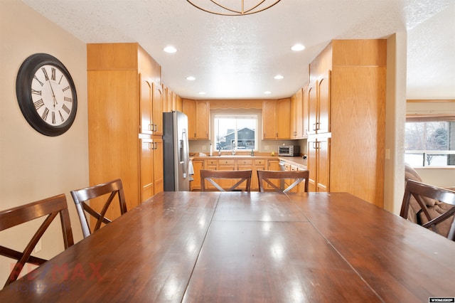 dining area featuring sink and a textured ceiling