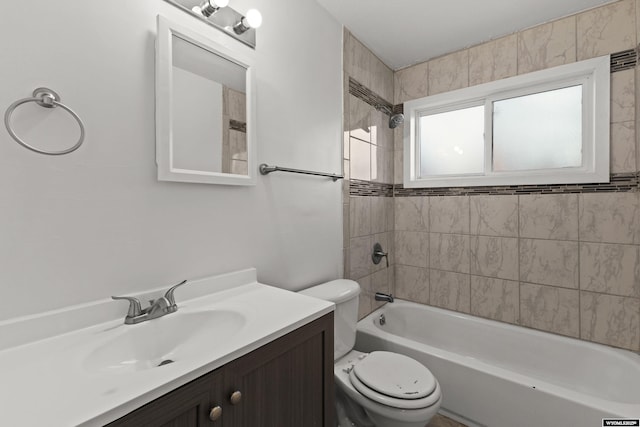 full bathroom featuring toilet, tiled shower / bath combo, and vanity