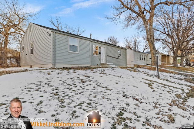 view of snow covered rear of property