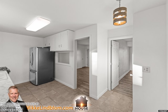 kitchen featuring pendant lighting, white cabinets, and stainless steel refrigerator