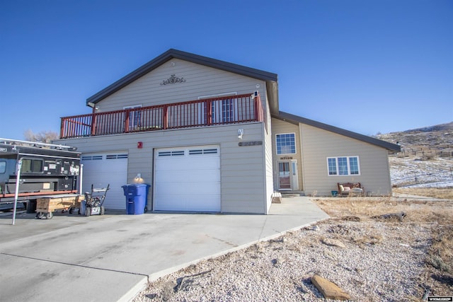 view of front of property featuring a balcony and a garage