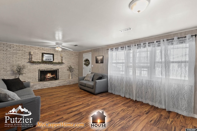 living room featuring hardwood / wood-style flooring, ceiling fan, and a fireplace