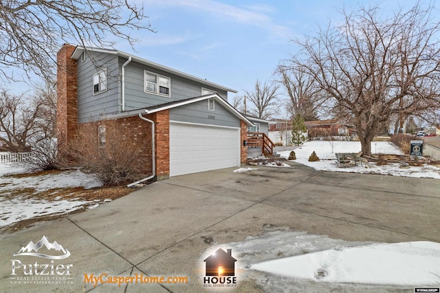 snow covered property with a garage