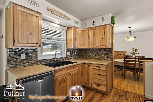 kitchen with stainless steel dishwasher, dark hardwood / wood-style flooring, decorative light fixtures, sink, and tasteful backsplash