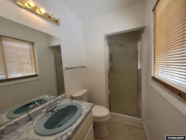 bathroom featuring tile patterned flooring, toilet, walk in shower, and vanity