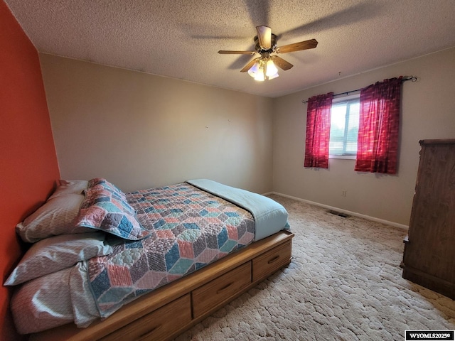 carpeted bedroom with ceiling fan and a textured ceiling