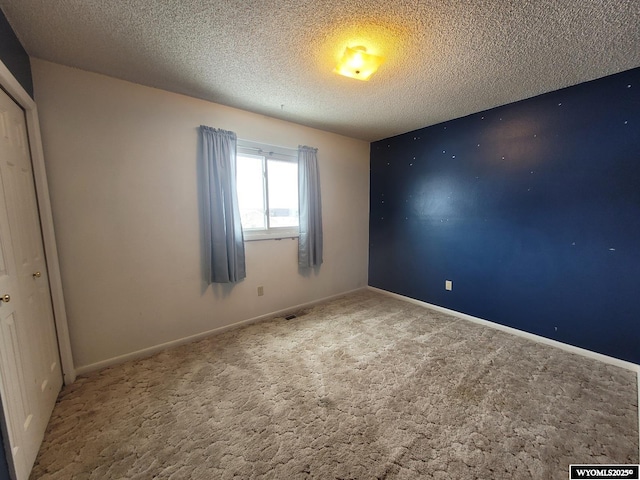 unfurnished bedroom featuring a textured ceiling and carpet flooring