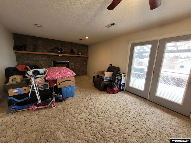 rec room with ceiling fan, a textured ceiling, and carpet flooring