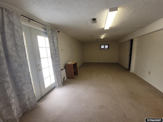 carpeted empty room with plenty of natural light and a textured ceiling