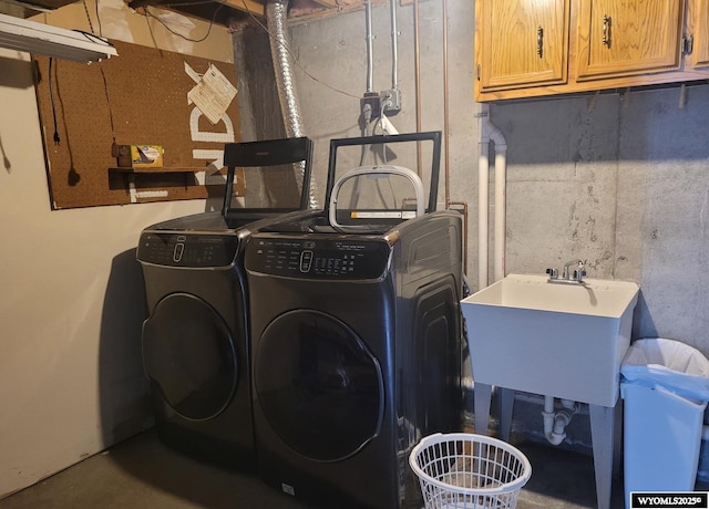 laundry room with cabinets, independent washer and dryer, and sink