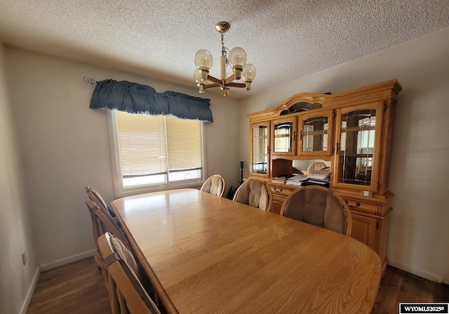 dining room featuring dark hardwood / wood-style flooring, a chandelier, and a textured ceiling