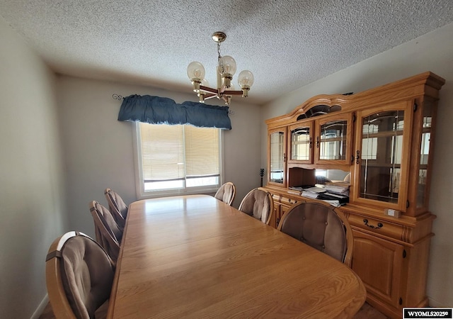 dining space with a textured ceiling and a chandelier