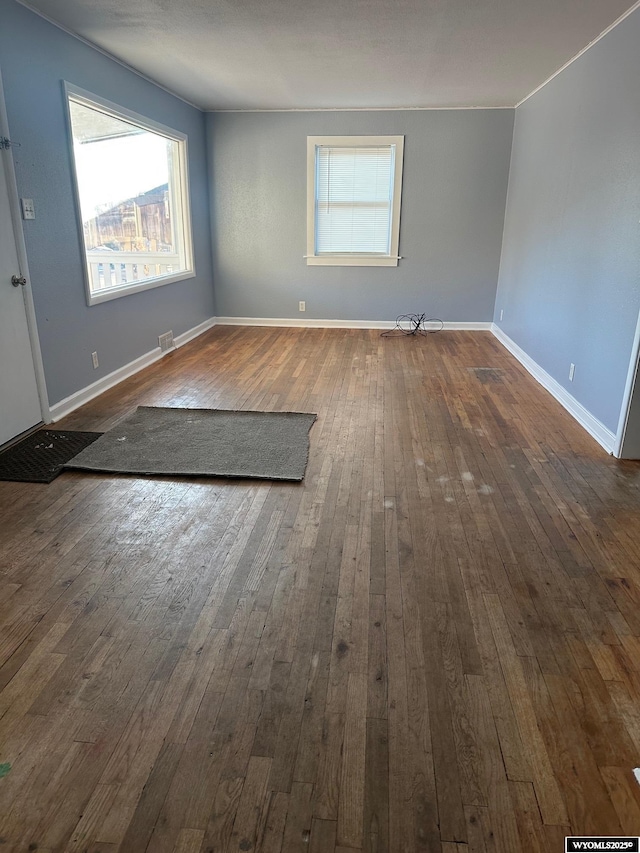 unfurnished room with dark wood-type flooring