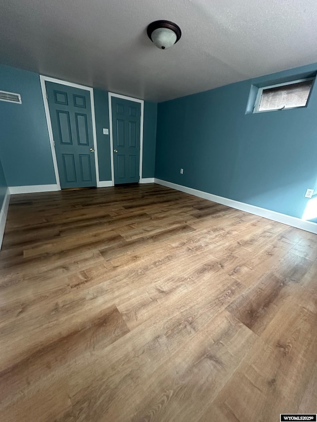 unfurnished bedroom featuring hardwood / wood-style flooring and a textured ceiling