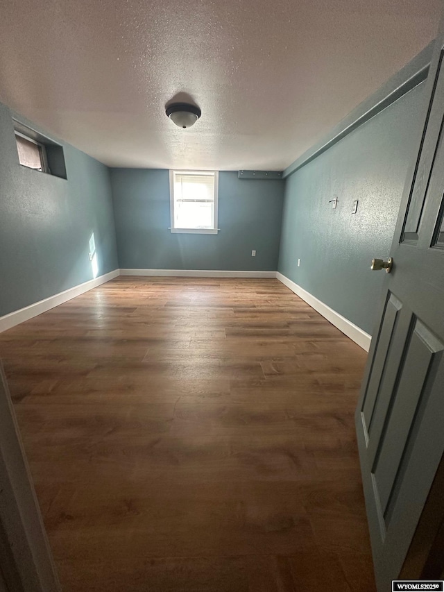 empty room featuring dark hardwood / wood-style floors and a textured ceiling