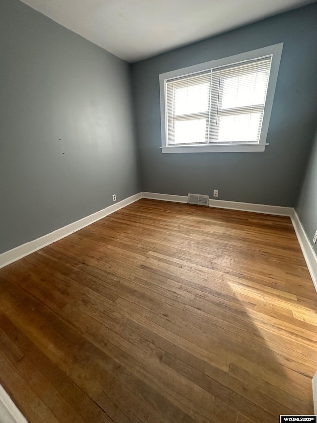 unfurnished room with wood-type flooring