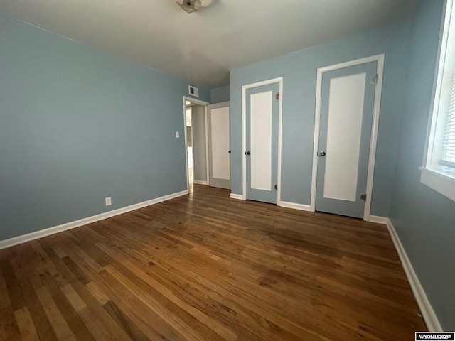 unfurnished bedroom featuring dark wood-type flooring