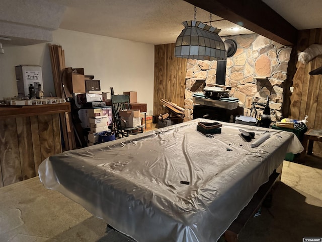 playroom with beamed ceiling, a wood stove, pool table, and a textured ceiling