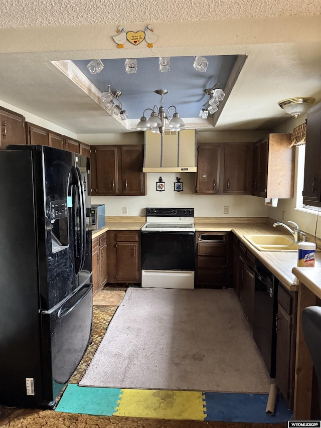 kitchen featuring sink, dark brown cabinets, a tray ceiling, a notable chandelier, and black appliances