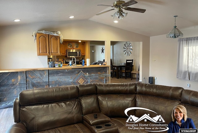 living room with lofted ceiling, ceiling fan, sink, and hardwood / wood-style flooring