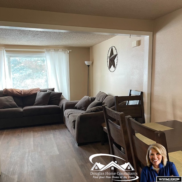 living room with a textured ceiling and hardwood / wood-style flooring