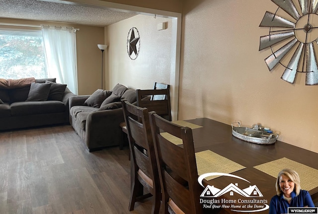 dining space featuring dark hardwood / wood-style floors and a textured ceiling