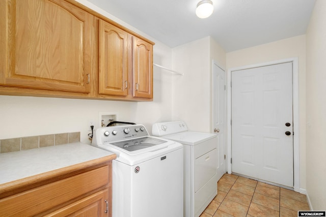 washroom with cabinet space, light tile patterned floors, and washer and clothes dryer