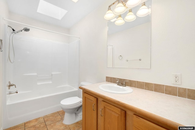 full bath with a skylight, toilet, tile patterned floors, vanity, and washtub / shower combination