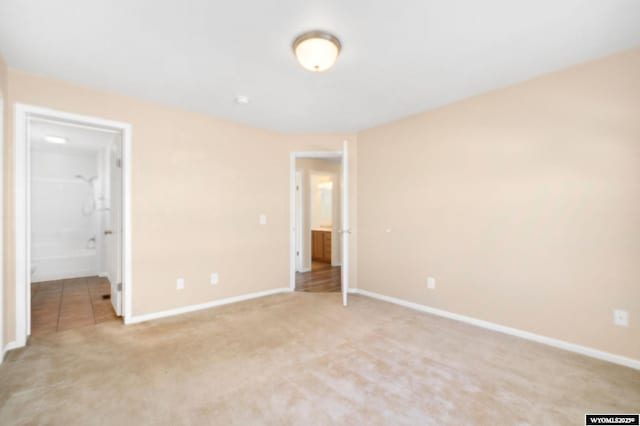 unfurnished bedroom with baseboards and light colored carpet